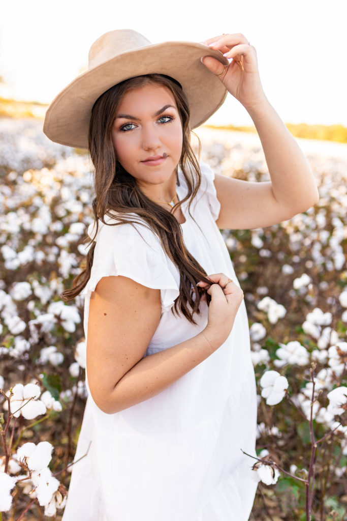 senior girl wearing hat in cotton field