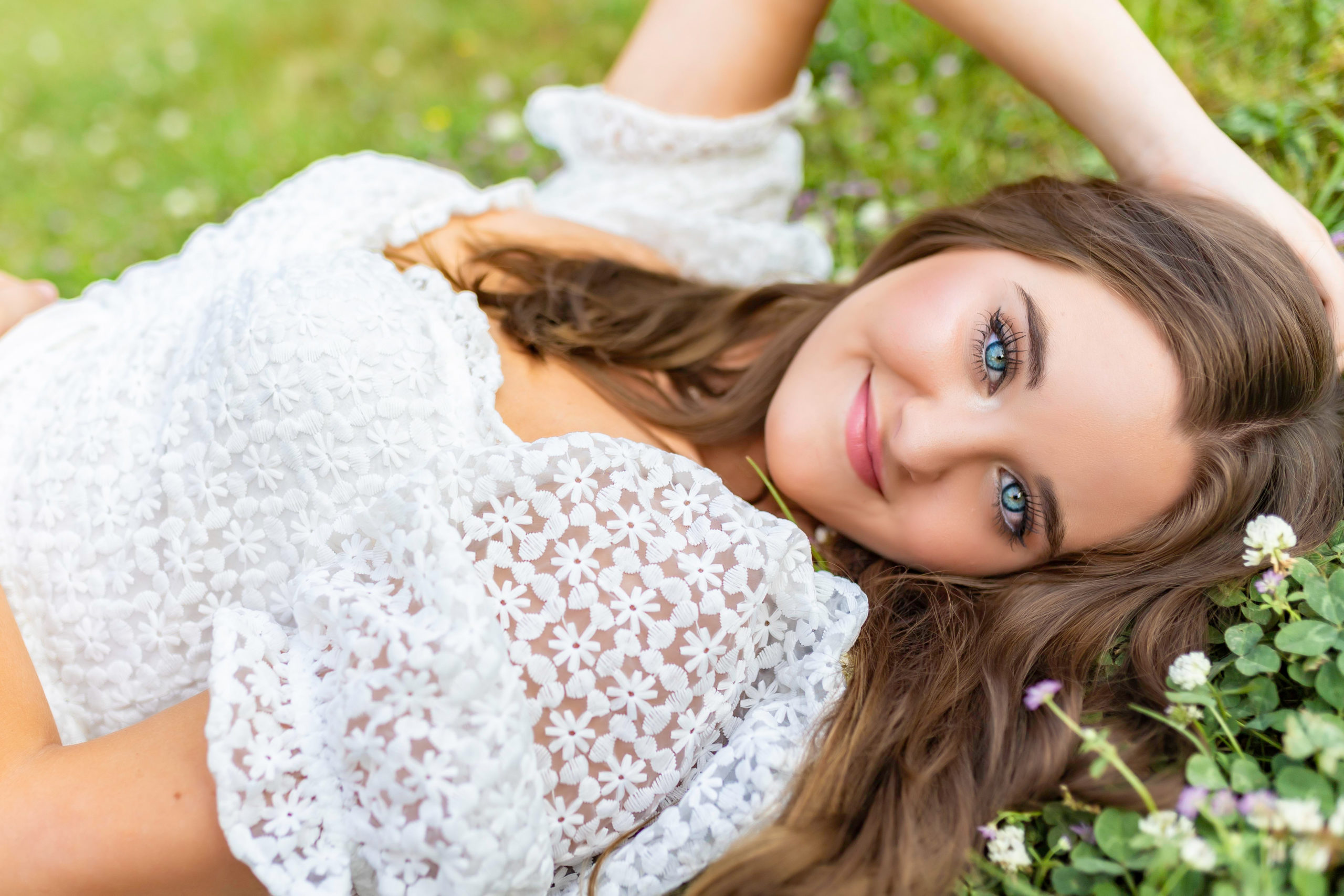senior girl posing in clover patch