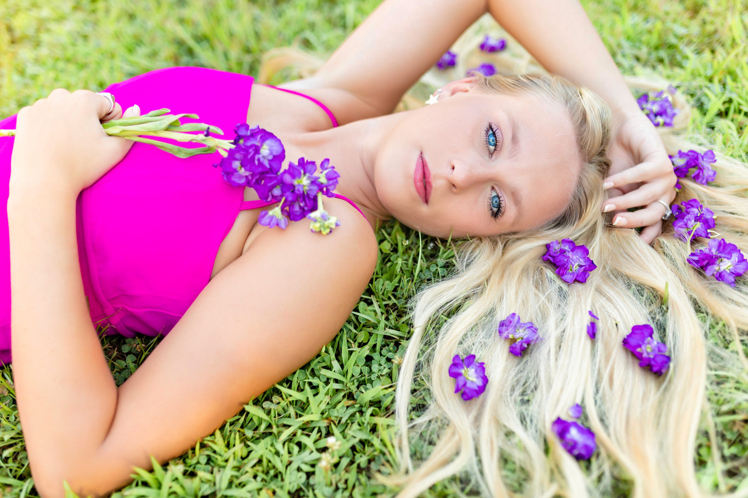 senior girl posing with purple flowers in hair