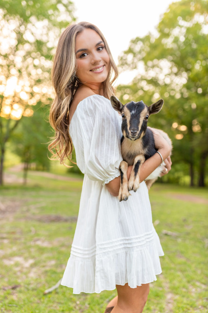 girl holding baby goat