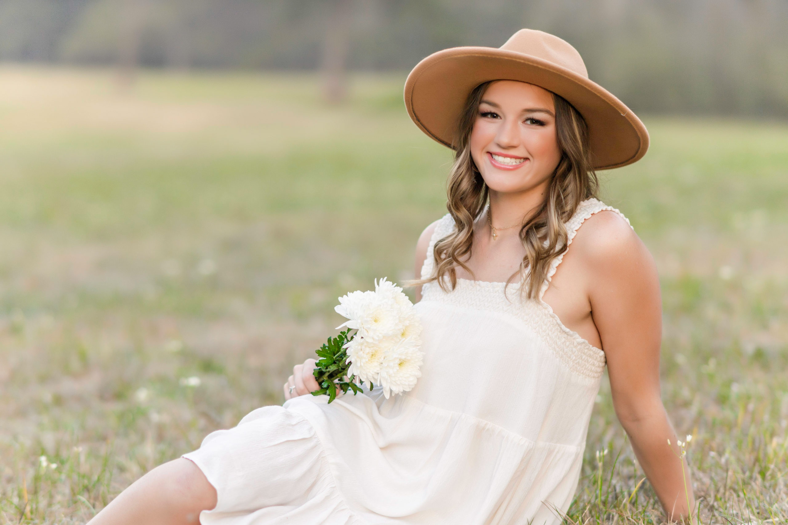 senior girl wearing hat in field